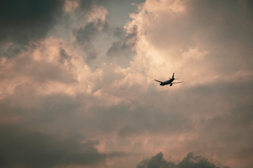 Fototapeta na wymiar Silhouette of a jumbo jet taking off with setting sun near international airport in Bengaluru