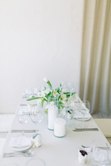  Light decor in the style of fine art. Glasses and tulips in the composition. Wedding table decor with white Studio.