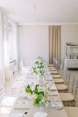  Light decor in the style of fine art. Glasses and tulips in the composition. Wedding table decor with white Studio.