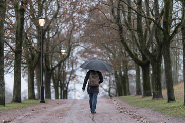 Hombre con paraguas en el parque