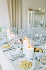 Light decor in the style of fine art. Glasses and tulips in the composition. Table setting for a feast. Wedding table decor in the white Studio.