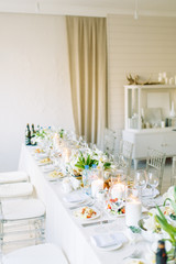 Light decor in the style of fine art. Glasses and tulips in the composition. Table setting for a feast. Wedding table decor in the white Studio.