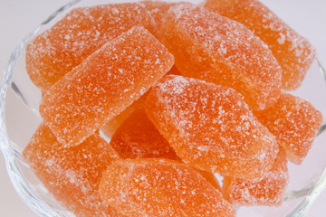 orange marmalade in a candy bowl on a white background