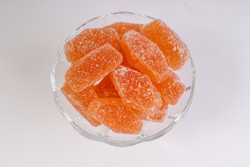 orange marmalade in a candy bowl on a white background