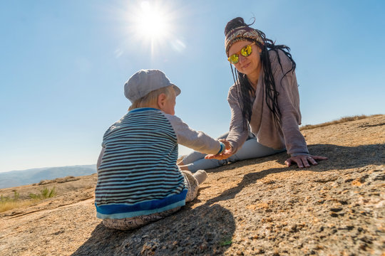 Mother with braids playing with one-year-old son outdoor