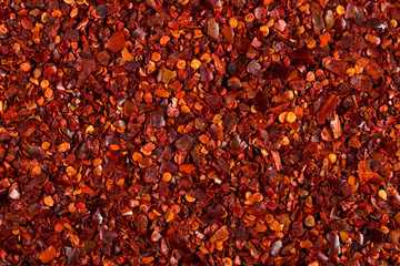 Crushed dried chili pepper red background, close-up macro. Concept, copy space.