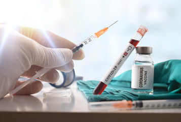 Sample with covid-19 and hand with syringe with vaccine dose