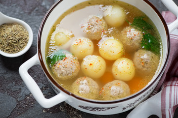 Bowl of soup with meatballs and potato balls, elevated view, horizontal shot