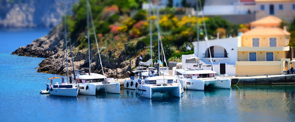 Fototapeta na wymiar Soft focus and tilt shift blur. Colorful Asos village at Kefalonia island. Greece. Popular destination on Ionian Sea for vacation. Mediterranean port for traveling by yacht and honeymoon paradise