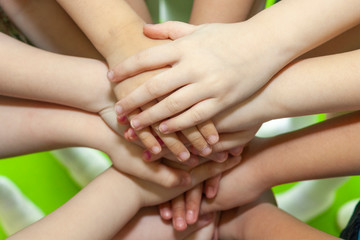 Children's hands piled on top of each other. Children's team and team building among the little guys.