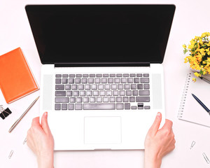 Woman hands holding laptop workspace with diary flowers