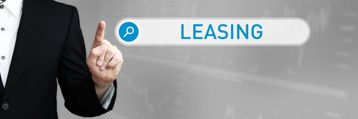 Leasing. Mann im Anzug zeigt mit dem Finger auf ein Suchfeld. Das Wort Leasing steht in der Suche. Symbol für Business, Finanzen, Statistik, Analyse, Wirtschaft