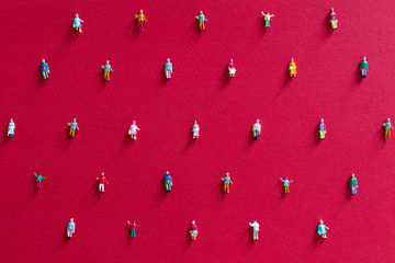 Social distancing concept to avoid coronavirus covid-19 sars-cov 2 spread aroung the country. Small miniature people on colored background distanced each other. Diffusion of coronavirus