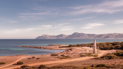 Watchtower Santa Margalida with sea and blue skies, mountains in the distance, located between Can...