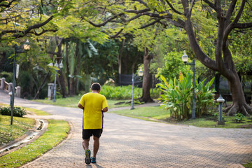 Fototapeta premium Old fat man run in park at morning