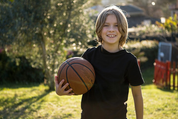 Ragazzo felice con il pallone da basket in mano