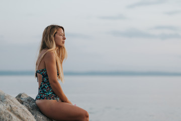 Fototapeta na wymiar Young woman enjoying sunset on the beach