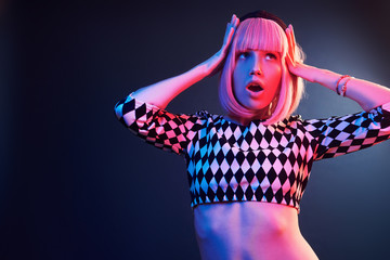 Portrait of young girl with blond hair in red and blue neon in studio