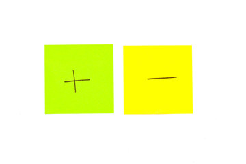 Two post its on white background with a plus and minus symbol