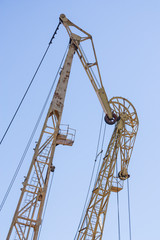 Large port cranes against a blue sky. Close-up of the construction elements of the crane.