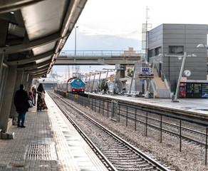 Fototapeta premium Intercity passenger train arrives at the Mirkaz Shmona railway station platform in Haifa, Israel