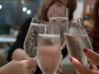 飲み会で4人の女性がシャンパンで乾杯する