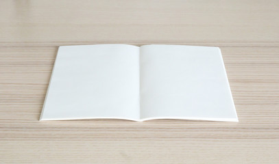 Mock up blank open paper book on wood table background