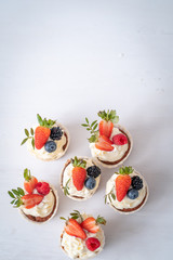 Fresh, delicious cupcakes with yogurt cream and fresh berries. Blur background.