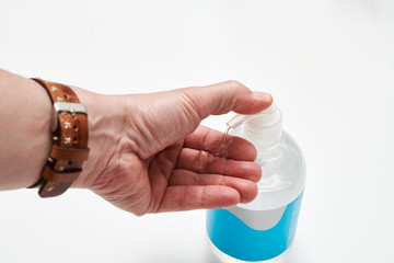 Close up of man's hands using antibacterial hand disinfection gel on white background