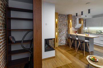 Stylish white kitchen set. Modern loft interior of studio apartment. Wooden shelves. Private house.
