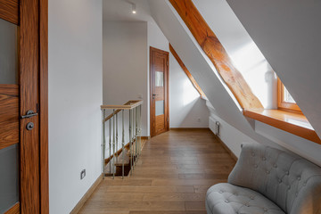 Modern loft interior of hall on the second floor in apartment. Cozy chairs. Wooden doors.