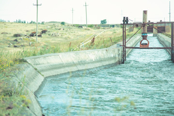 Canal lock gates and water bypass with trees