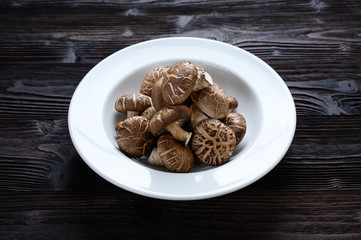 Shiitake mushrooms on the wooden background.