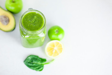 glass of green smoothie detox drink and a set of products for preparation: lemon, apple, avocado, spinach. Morning detox for a healthy lifestyle, weight loss, ketone diet, raw food diet
