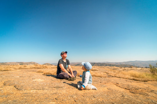 Father enjoying sun while playing with baby son outdoor