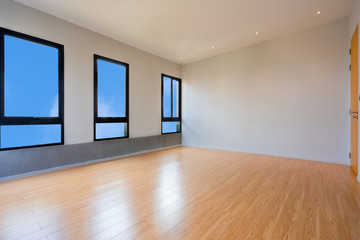 Empty room interior with windows overlooking the blue sky, Beautiful wooden floor and white wall modern architecture