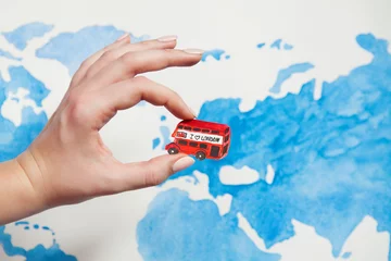 Poster Travel concept. Watercolor illustration of London red bus with text "I love London" in a woman's hand. Background world map watercolor illustration © Liudmyla