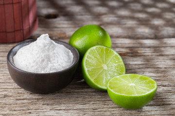Baking soda and lemon on wooden background space for text