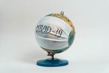 Earth globe with medical mask on white background, global pandemic covid-19, coronavirus 