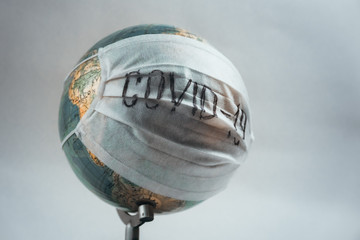 Earth globe with medical mask on white background, global pandemic covid-19, coronavirus 