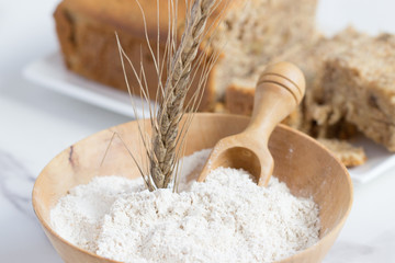 espiga de cereal con harina en cuenco de madera