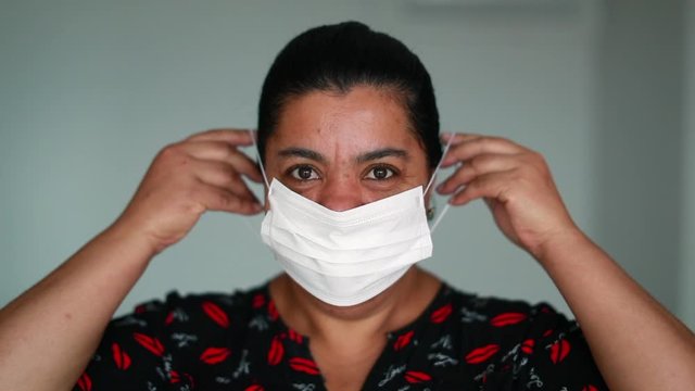 African american black woman putting on face mask for protection against Covid 19 pandemia