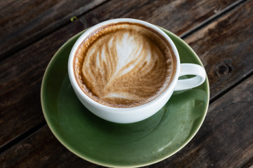 Black coffee cup on old wooden table top view. note book and pencil. lifestyle concept