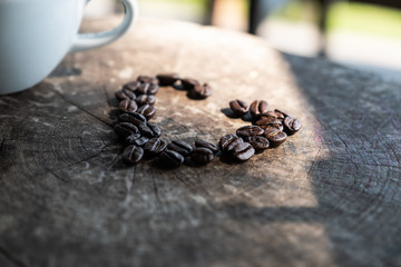 Black coffee cup on old wooden table top view. note book and pencil. lifestyle concept