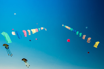 Beautiful colorful kite flying in the wind with blue sky in background.