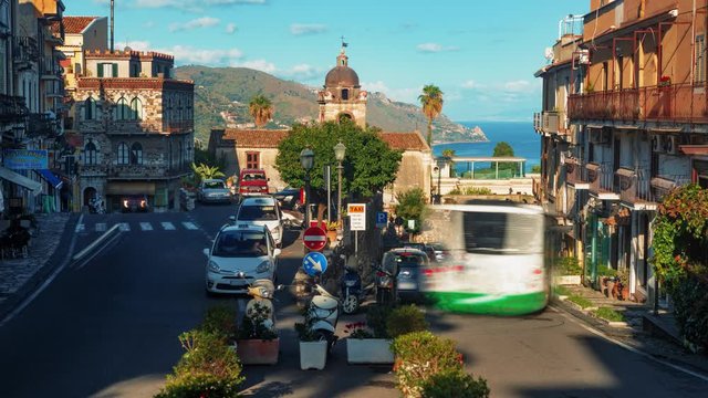 Timelapse vew of a crossroad in Taormina with the East coast of Sicily in the background