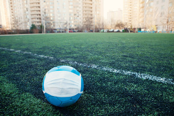Soccer ball in protective mask due to epidemic or air pollution. Concept protection from viruses, infections,  industrial emissions, exhaust gases  