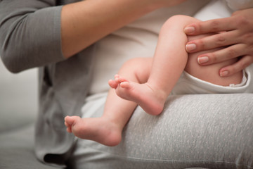 Fototapeta na wymiar Baby feet in mother hands. Mom and her Child. Happy Family concept. Beautiful conceptual image of Maternity.