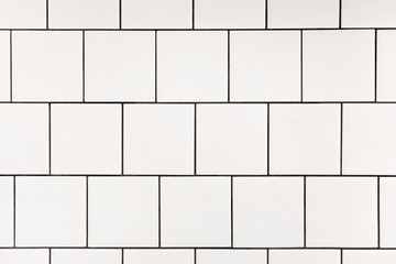 White square ceramic tile with black seam, located horizontally. Abstract background, ceramic texture.