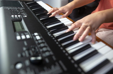 Obraz premium Young female beginner teaches itself playing on the electric piano, instrument playing, teachning